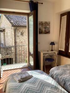Schlafzimmer mit einem Bett, einem Schreibtisch und einem Fenster in der Unterkunft Casa Balani in Assisi