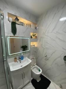 a white bathroom with a sink and a toilet at Cozy Peckham Apartments in London