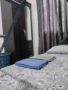 a bedroom with two beds and a black door at Vin's Place Rentals in Tagum