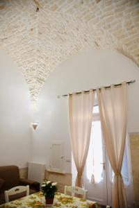Habitación con mesa con cortinas y sofá en La casa di Nonno Peppe, en Martina Franca 9 fotos más