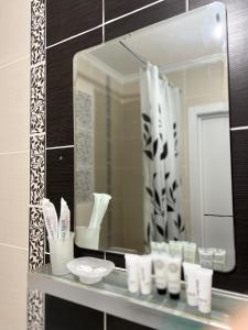 a bathroom with a mirror and a shelf with toiletries at Hyat apartment in Bishkek