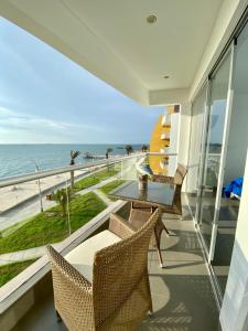 balcón con mesa, sillas y vistas al océano en Condominio Nuevo Paracas - Sotavento, en Paracas