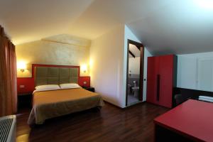 a hotel room with a bed and a bathroom at Lux Hotel Durante in Milan