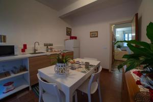una cucina con tavolo e sedie bianchi in una stanza di Oasi nel Cuore di Lucca, super centrale e luminoso a Lucca