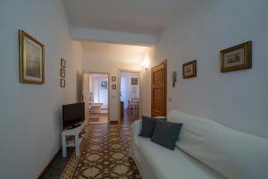 un soggiorno con divano bianco e TV di Oasi nel Cuore di Lucca, super centrale e luminoso a Lucca