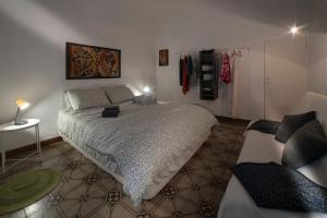 a bedroom with a large bed and a couch at Oasi nel Cuore di Lucca, super centrale e luminoso in Lucca