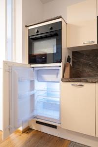 einem leeren Kühlschrank mit offener Tür in der Küche in der Unterkunft Modern apartment w/ cozy balcony near city center in Wien