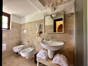 łazienka z umywalką, toaletą i lustrem w obiekcie Savito Guest House w mieście Martina Franca