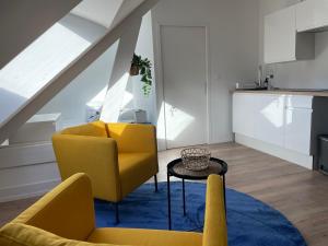 a living room with two yellow chairs and a table at Studio 303 - Hyper Centre - Intégralement rénové - Toutes commodités à pied in Saint-Nazaire