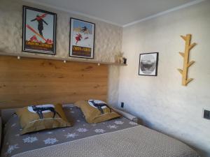 a bedroom with a bed with posters on the wall at Fradusta 213 in San Martino di Castrozza