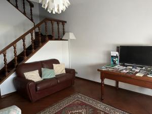 uma sala de estar com um sofá castanho e uma mesa em Home Azzurra em Capolona