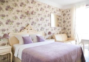 a bedroom with a large bed with purple pillows at Croisette Palais Miramar Cannes Imperial in Cannes