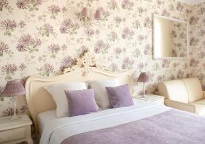 a bedroom with a large bed with purple flowers at Croisette Palais Miramar Cannes Imperial in Cannes