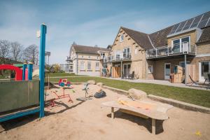 un parco giochi di fronte a una casa di Büdlfarm - Der Familien-Erlebnishof in Strandnähe a Fehmarn