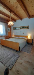 um quarto com uma cama grande e um tecto de madeira em Almhaus Tschamutsch em Niederwinklern