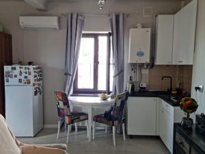 a kitchen with a table and chairs and a refrigerator at Cosy studio in Bucharest