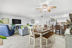 a dining room and living room with a table and chairs at Beach Oasis - Beautifully Remodeled Beachside Condo at Holiday Villas II with Heated Pool! in Clearwater Beach