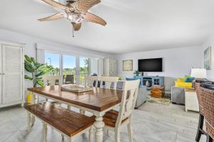 a dining room with a table and a ceiling fan at Beach Oasis - Beautifully Remodeled Beachside Condo at Holiday Villas II with Heated Pool! in Clearwater Beach