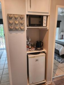 a small kitchen with a stove and a microwave at Rosewood Guest Cottage in Vryheid