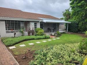 a garden in front of a house at Rosewood Guest Cottage in Vryheid