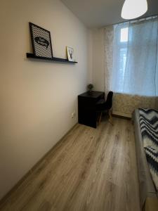 ジェシュフにあるKwadrat Apartamenty Grottgeraのデスク、ベッド、テーブルが備わる客室です。