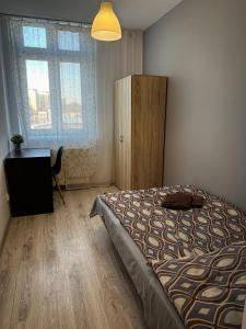 a bedroom with a bed and a dresser and a window at Kwadrat Apartamenty Grottgera in Rzeszów