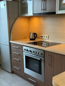 a kitchen with a stainless steel stove and refrigerator at Dārzu ielas apartamenti in Rēzekne