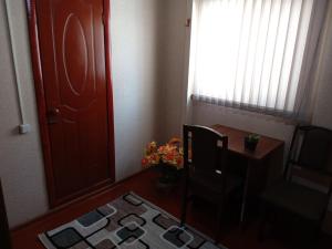 een kamer met een deur, een stoel en een tafel bij Sayfi Guesthouse in Doesjanbe
