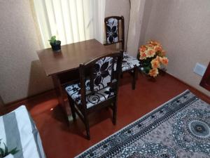 a table and a chair with a table and flowers at Sayfi Guesthouse in Dushanbe