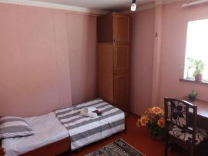 een kleine slaapkamer met een bed en een raam bij Sayfi Guesthouse in Doesjanbe