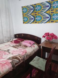 ドゥシャンベにあるSayfi Guesthouseのベッドルーム1室(ベッド1台、花瓶付きのテーブル付)