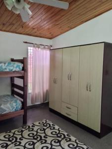 a bedroom with a bunk bed and a closet with a ceiling at Alojamiento Alem in General Alvear