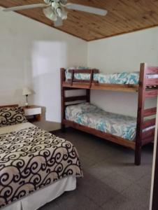 a bedroom with two bunk beds and a ceiling fan at Alojamiento Alem in General Alvear