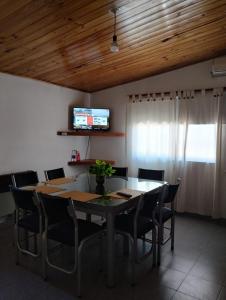 uma sala de jantar com uma mesa e cadeiras e uma televisão em Alojamiento Alem em General Alvear