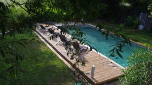 a wooden deck with chairs in a swimming pool at Le Robinson in Pierrelatte