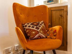 a teddy bear sitting on a chair with pillows at Charming Victorian Hidden Gem - Pass the Keys in Market Drayton +27 photos
