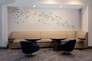 a waiting room with tables and a couch and birds on the wall at Cincinnati Marriott at RiverCenter in Covington