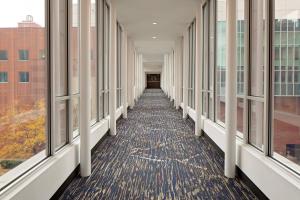 an empty hallway in a building with windows at Cincinnati Marriott at RiverCenter in Covington