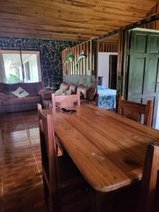 una mesa de madera en una sala de estar con sofá en Hospedaje las brisas, en Puerto Jiménez
