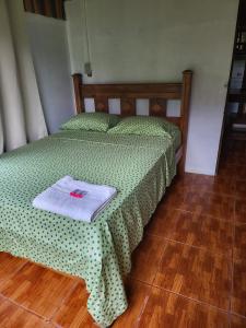 Un dormitorio con una cama con una toalla. en Hospedaje las brisas, en Puerto Jiménez