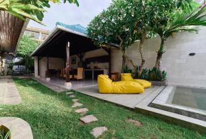 una casa con dos grandes objetos amarillos en el patio en Cantik ArtVilla, en Uluwatu