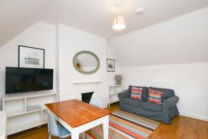 a living room with a couch and a tv at The Dagmar Grove Apartments in Nottingham