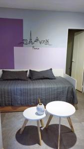 1 dormitorio con 1 cama con 2 mesas delante en DEPARTAMENTO VILLA CARLOS PAZ a 8 cuadras del centro en Villa Carlos Paz