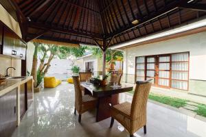 cocina abierta y comedor con mesa y sillas en Cantik ArtVilla, en Uluwatu