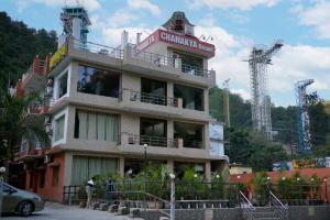 a building with a sign on top of it at Chanakya Resort in Rishīkesh