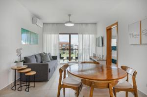 sala de estar con mesa y sofá en Apartamento vista a piscina, gym y cerca de playa, en Punta Cana