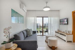 sala de estar con sofá y mesa en Apartamento vista a piscina, gym y cerca de playa en Punta Cana