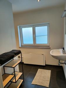 a bathroom with a sink and a toilet and a window at Aan de Keiberg in Bilzen