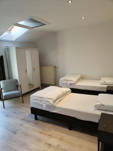 een kamer met 2 bedden, een stoel en een dakraam bij Aan de Keiberg in Bilzen