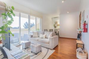 a living room with a couch and a large window at Blue Sky in Funchal